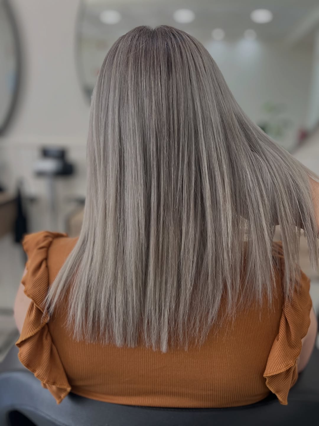 Loiro acinzentado liso e luminoso, visto de costas no salão