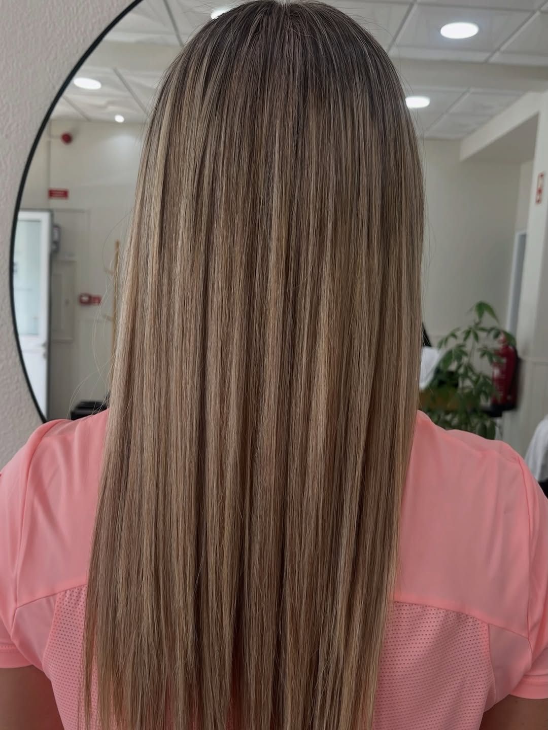Madeixas naturais em cabelo comprido, com o interior luminoso do estúdio ao fundo