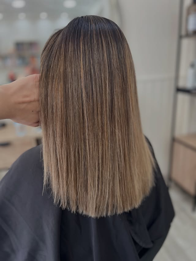 Corte lob liso, com transição suave de castanho para loiro