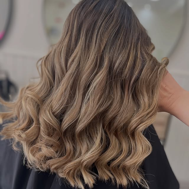 Ondas largas em tons de mel e areia, vistas de costas